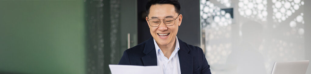 a man holds an EB-5 note, reviewing it for investor immigration.