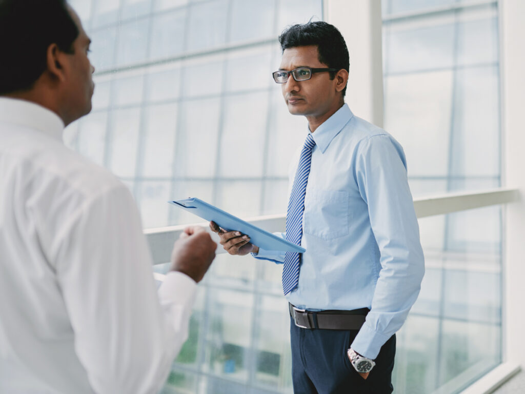 an Indian investor discussing his documents with someone from capital visa services