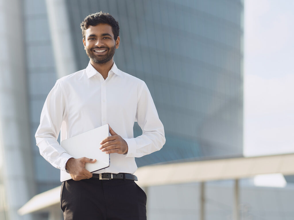 Indian investor holding a laptop with his files for i-485 inventory