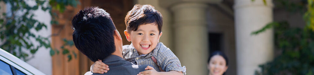 A happy foreign eb5 investor carrying his child and with his family