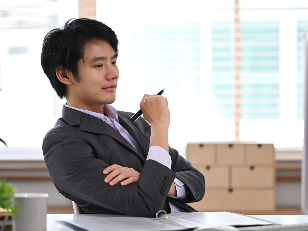 A foreign investor doing due diligence eb5 while reviewing files on his desk