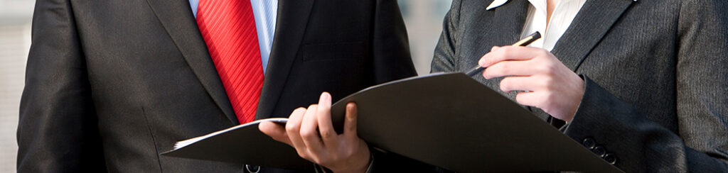 Two people reviewing a document while in the midst of performing an investment risk analysis